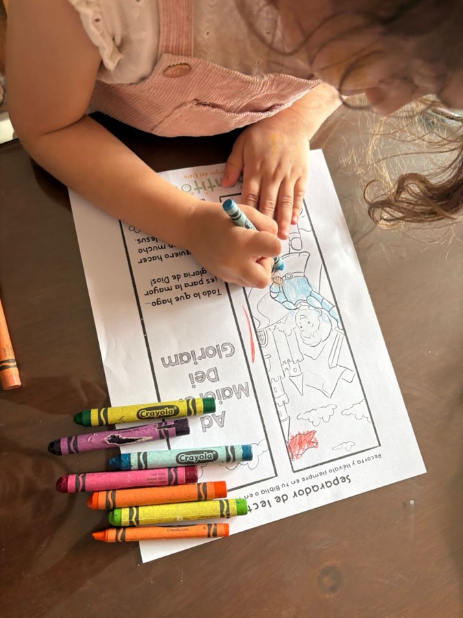 Una niña colorea su separador de lectura